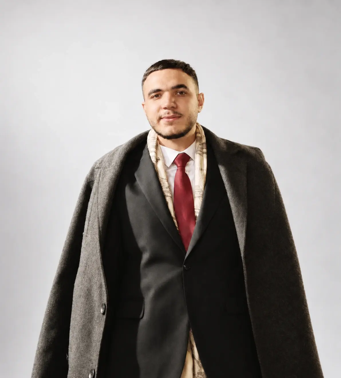 Abdulrahman Elsayed in a dark suit and beige scarf